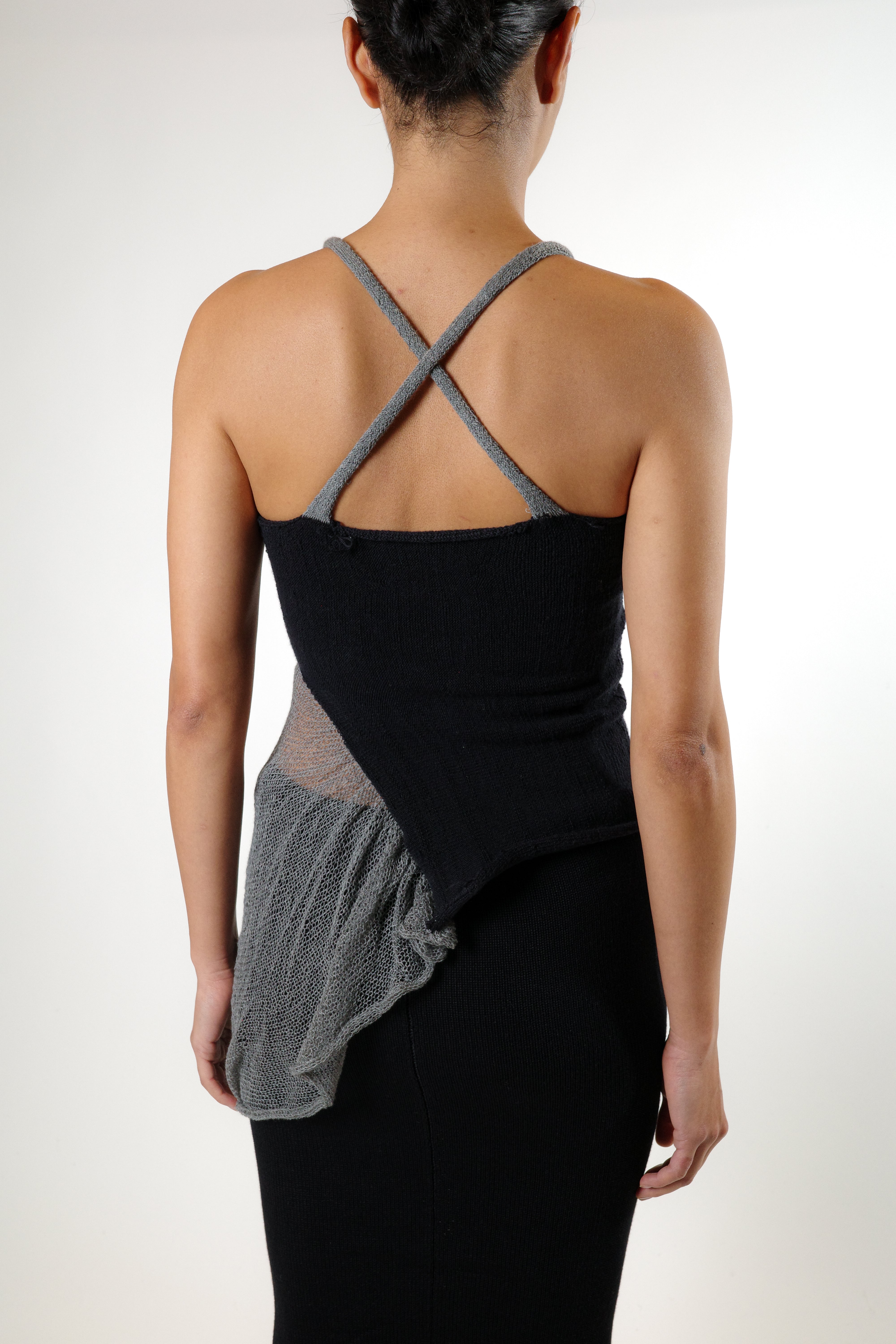 Back view of black knit top with X shaped straps and fitted silhouette