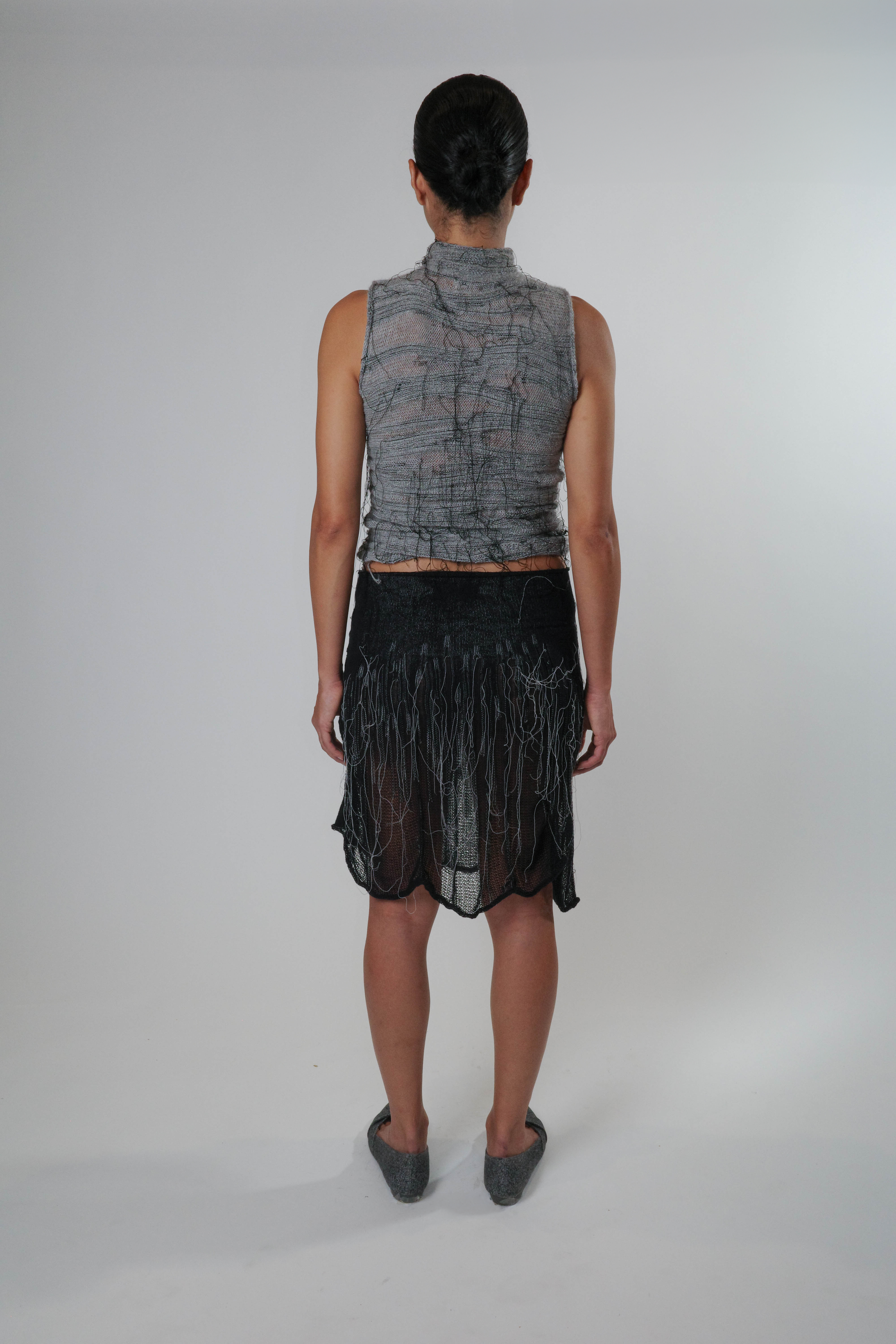 Black knit piece with organic detailing, styled as a skirt, lightweight and semi sheer