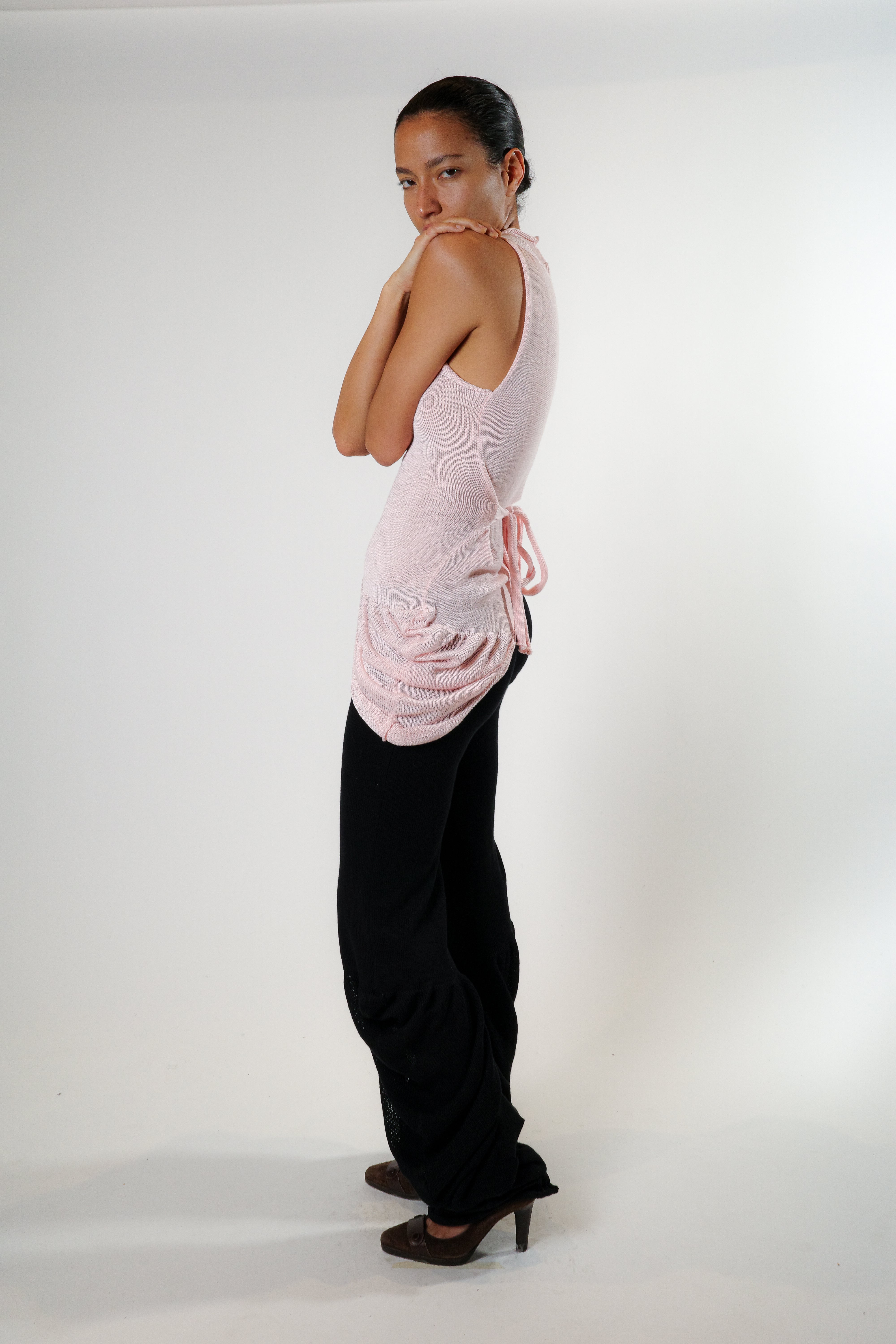 Side view of pink knit top with gathered drape detail and adjustable ties, relaxed silhouette
