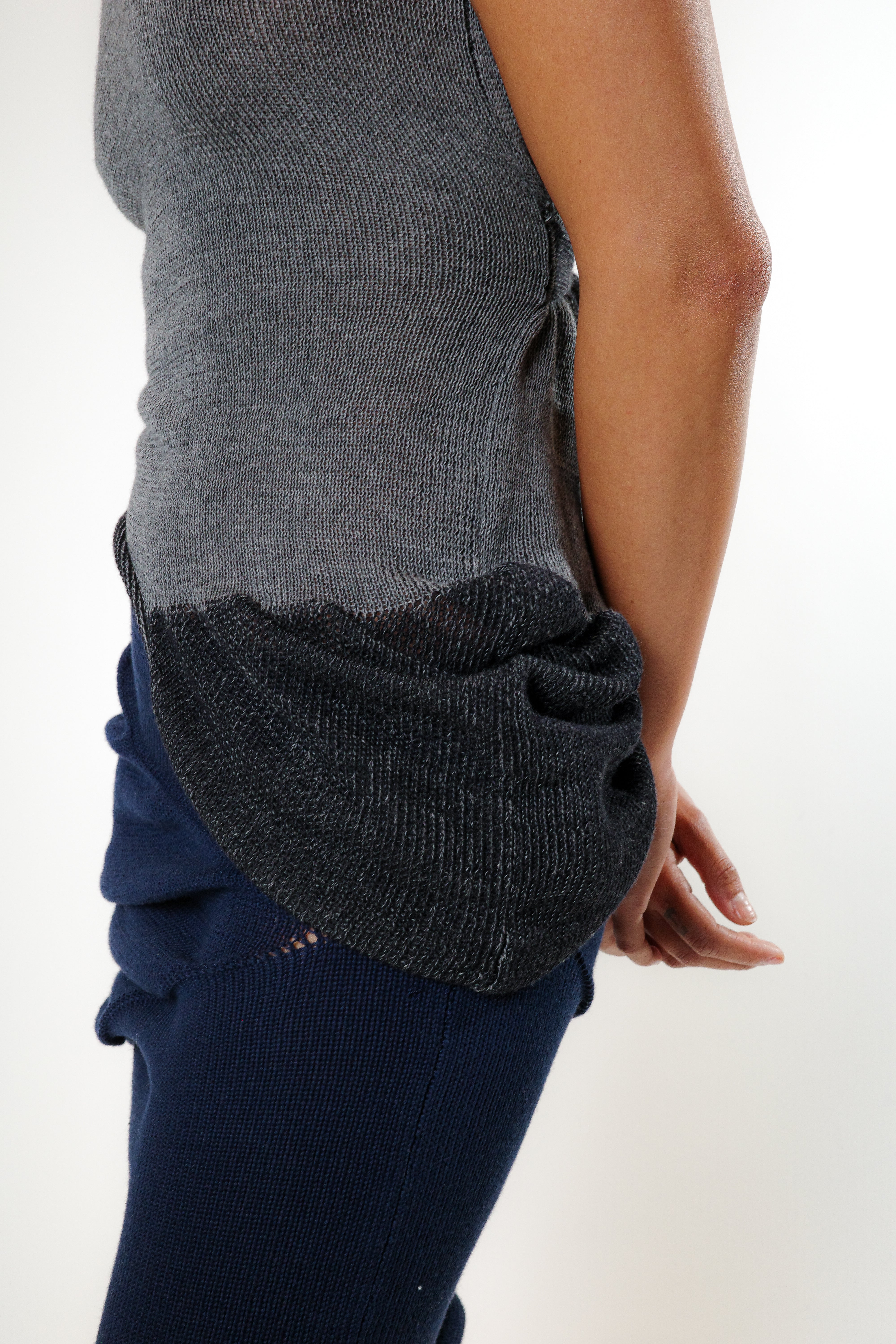 Side view of grey knit top with gathered drape detail and adjustable ties